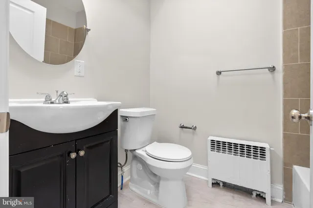 a bathroom with a sink a toilet and mirror