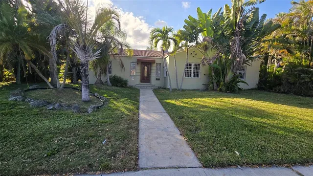 a view of a yard with plants and trees