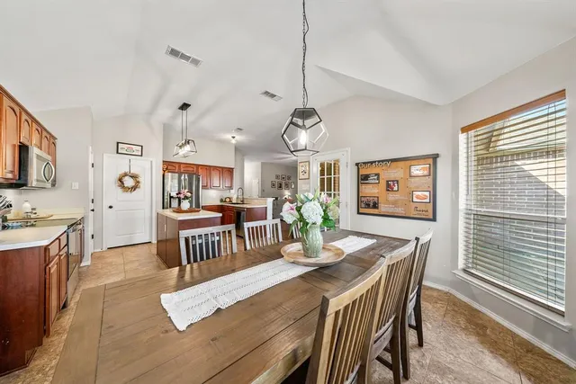a living room with couches a computer on a desk and kitchen view