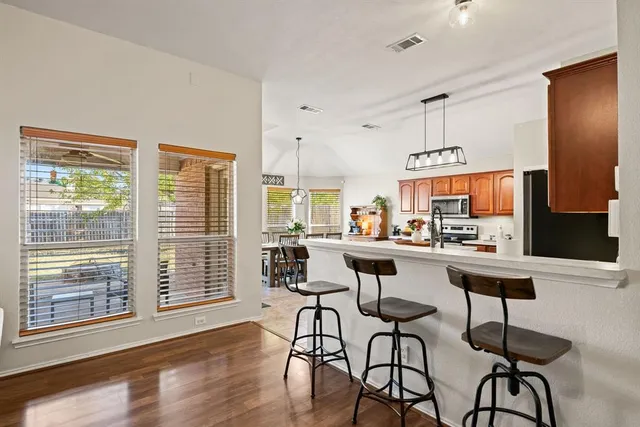 a room with stainless steel appliances kitchen island granite countertop furniture and a large window