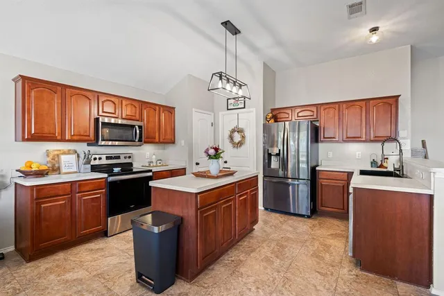 a kitchen with stainless steel appliances granite countertop a stove refrigerator sink and dishwasher