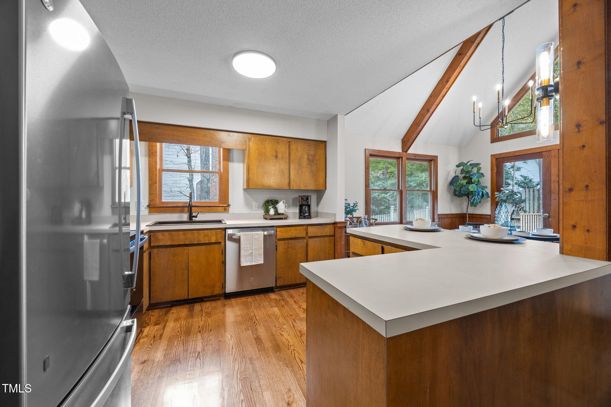 2508 Village Grove Road Raleigh, NC 27613 - Photo 15 of 36 a kitchen with a refrigerator a sink dishwasher with a dining table and chairs