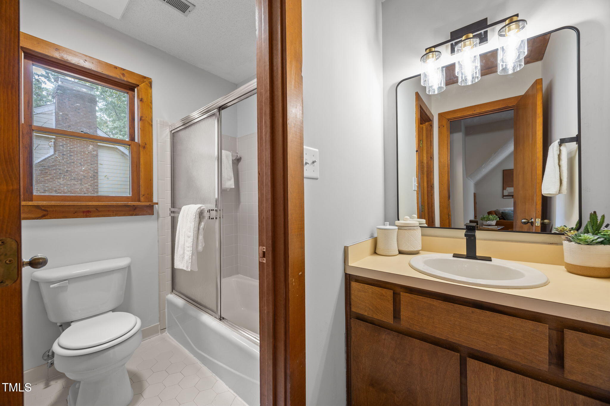 2508 Village Grove Road Raleigh, NC 27613 - Photo 27 of 36 a bathroom with a sink a toilet and a mirror