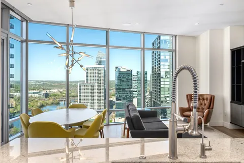 a kitchen with stainless steel appliances kitchen island granite countertop a sink and a refrigerator