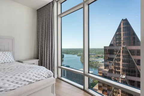 a bedroom with a bed and a large window