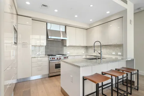 a kitchen with kitchen island a stove a sink and a refrigerator