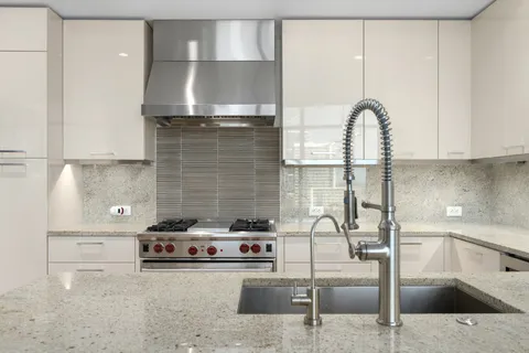a kitchen with stainless steel appliances granite countertop a sink a stove and a refrigerator
