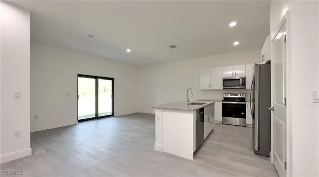 a kitchen with a sink a refrigerator and cabinets