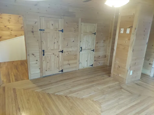 a kitchen with stainless steel appliances granite countertop wooden cabinets a refrigerator a stove a sink and dishwasher with wooden floor