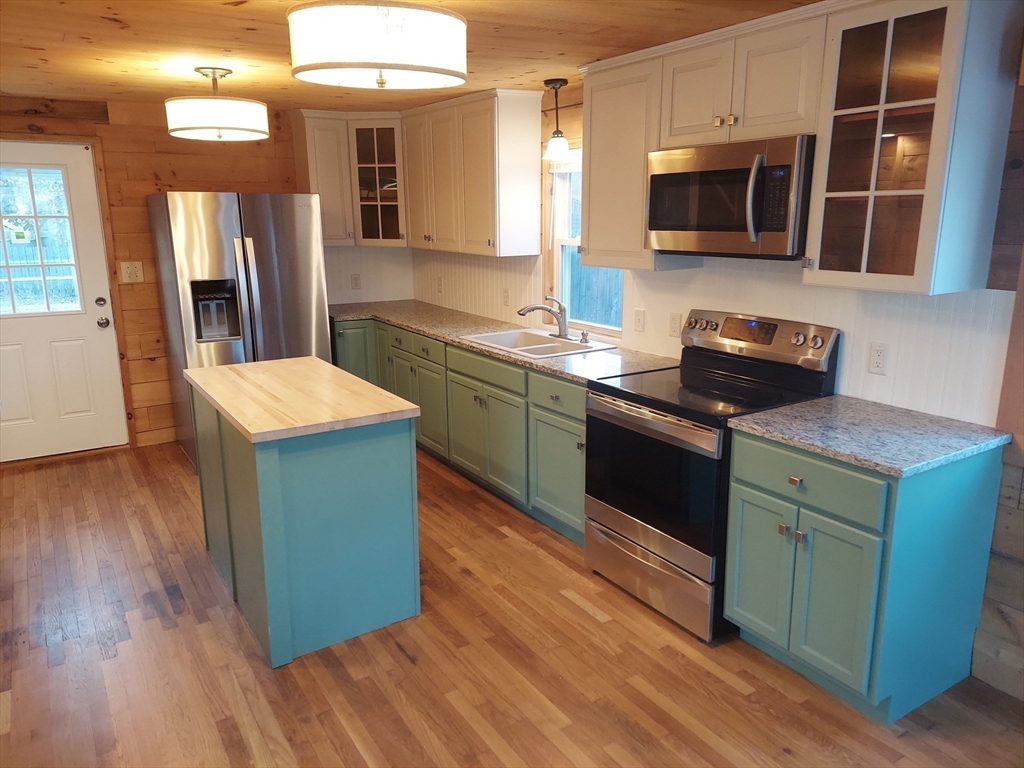 8 Phillips Street Attleboro, MA 02703 - Photo 7 of 17 a kitchen with stainless steel appliances kitchen island granite countertop a stove a sink and a microwave