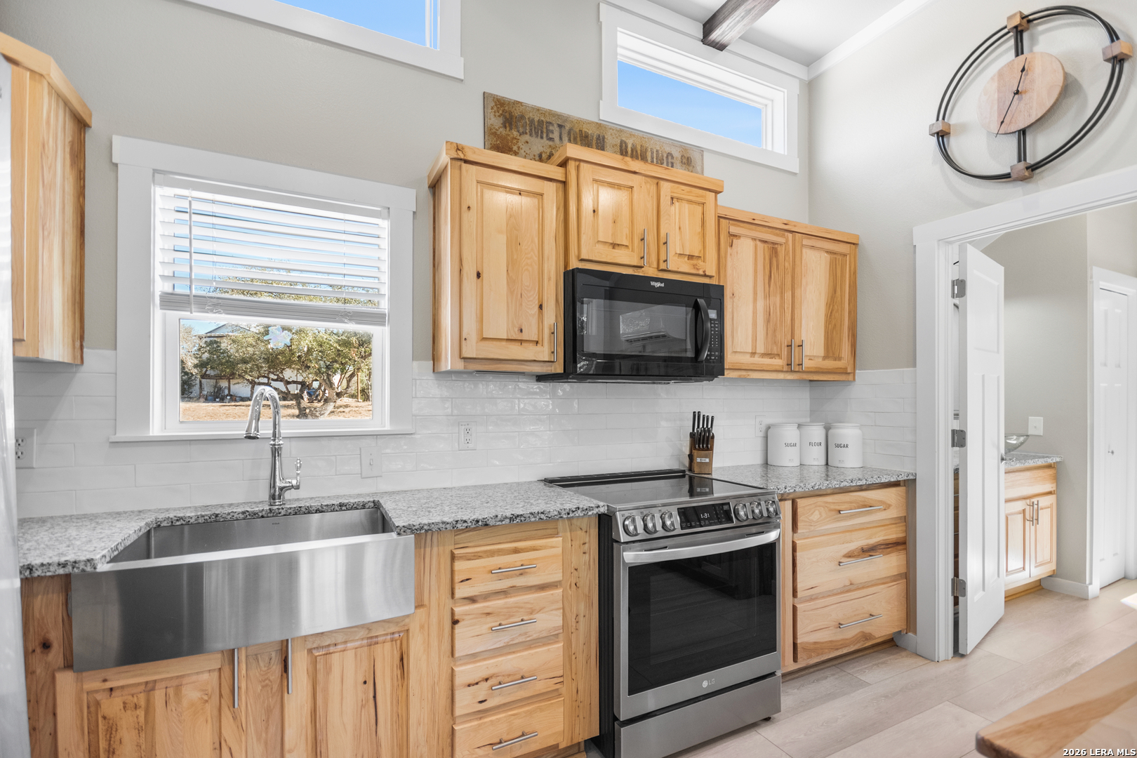 292 Fossil Ridge Boerne, TX 78006 - Photo 101 of 144 a kitchen with stainless steel appliances granite countertop a sink a stove a microwave oven with cabinets and wooden floor
