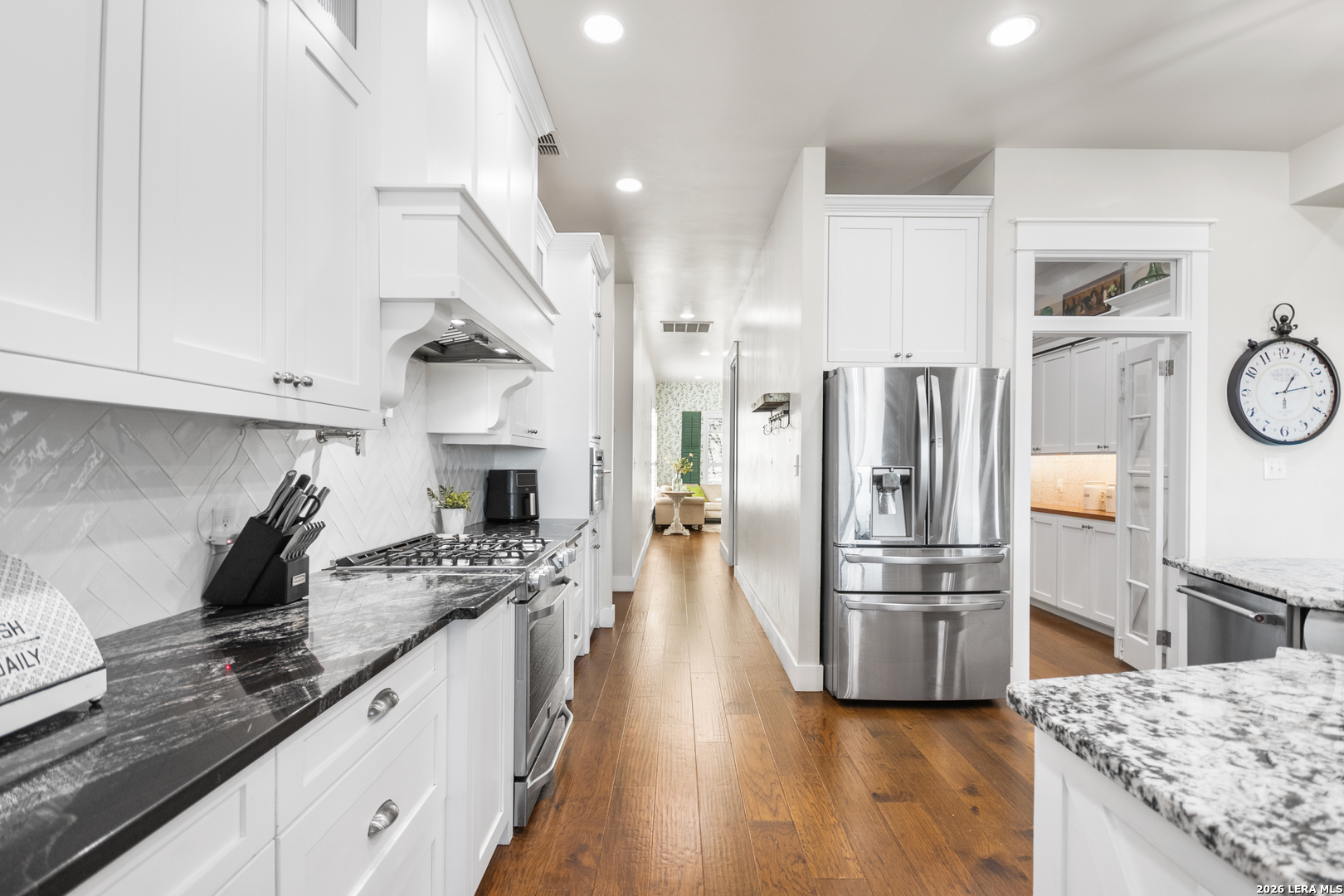 292 Fossil Ridge Boerne, TX 78006 - Photo 24 of 144 a kitchen with stainless steel appliances kitchen island granite countertop a refrigerator a stove and white cabinets with wooden floor