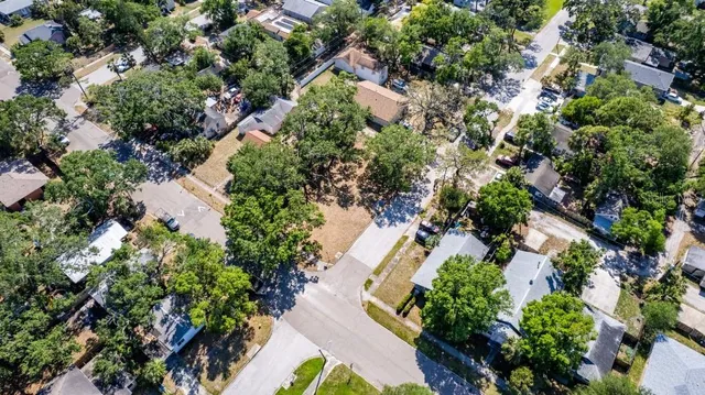 an aerial view of residential house with outdoor space and trees all around