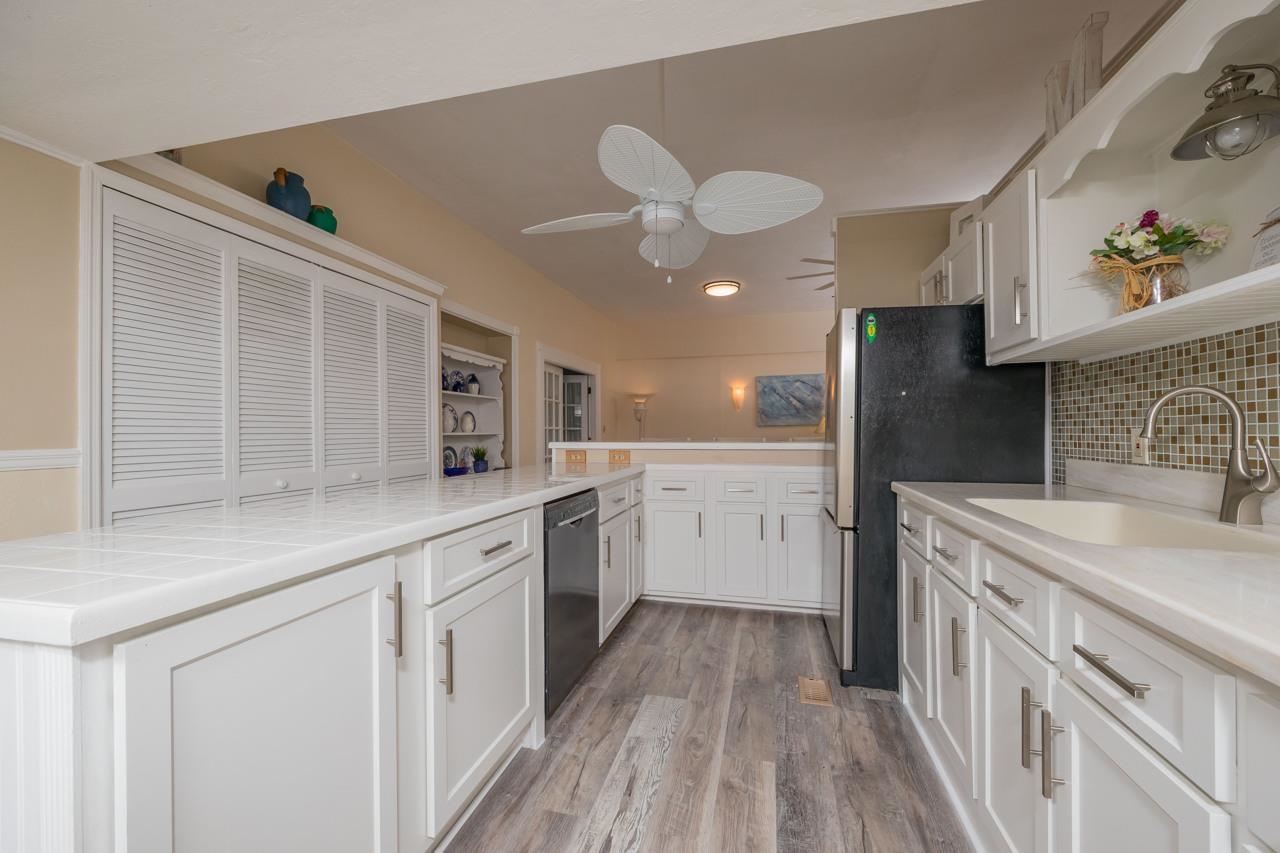 248 Majorca Road St. Augustine, FL 32080 - Photo 8 of 48 a kitchen with a sink dishwasher refrigerator stove and white cabinets with wooden floor