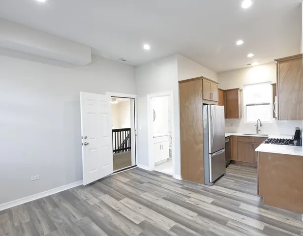 a kitchen with stainless steel appliances a refrigerator and a stove top oven