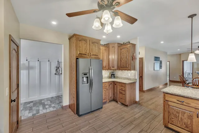 a kitchen with stainless steel appliances a refrigerator a sink cabinets and wooden floor