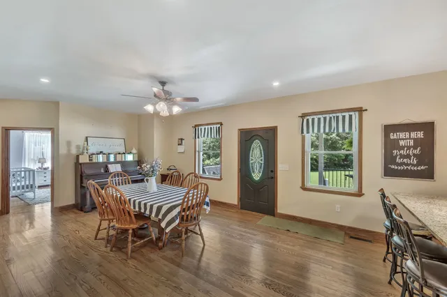 a dining room with furniture a chandelier and wooden floor