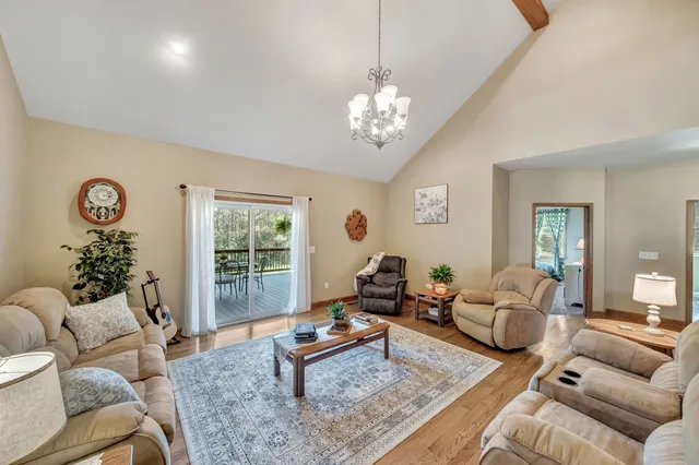 a living room with furniture a chandelier and a window