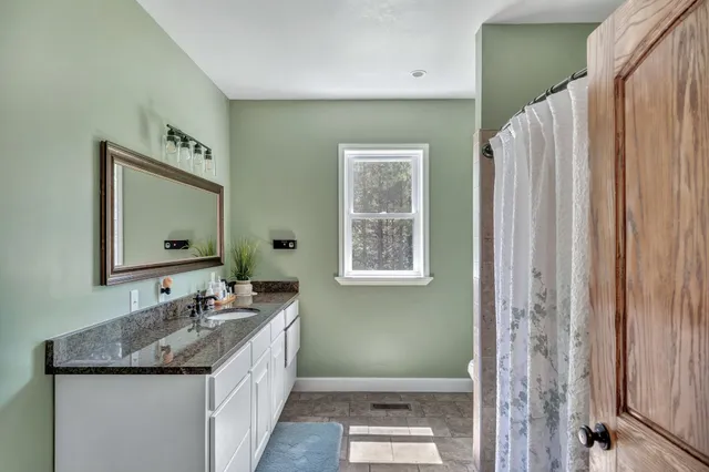 a bathroom with a granite countertop sink and a mirror