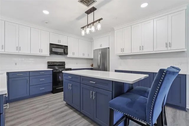 a kitchen with stainless steel appliances granite countertop a sink dishwasher stove and microwave with wooden cabinets