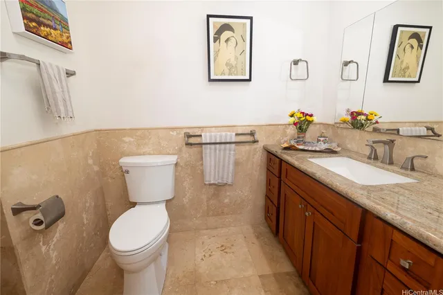 a bathroom with a granite countertop sink mirror vanity and toilet