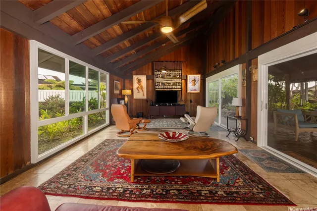 a living room with furniture a rug and a floor to ceiling window