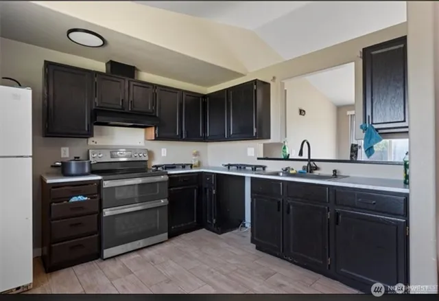 a kitchen with a sink cabinets and stainless steel appliances