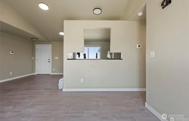 an empty room with wooden floor and mirror