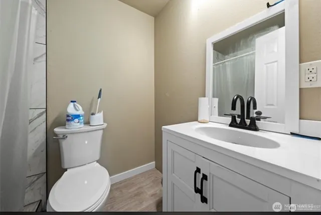 a bathroom with a sink a toilet and mirror