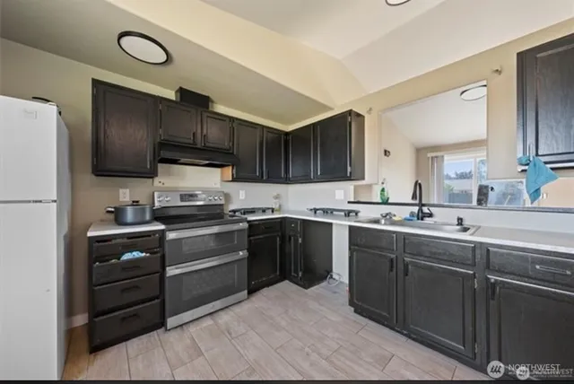 a kitchen with a sink cabinets and stainless steel appliances