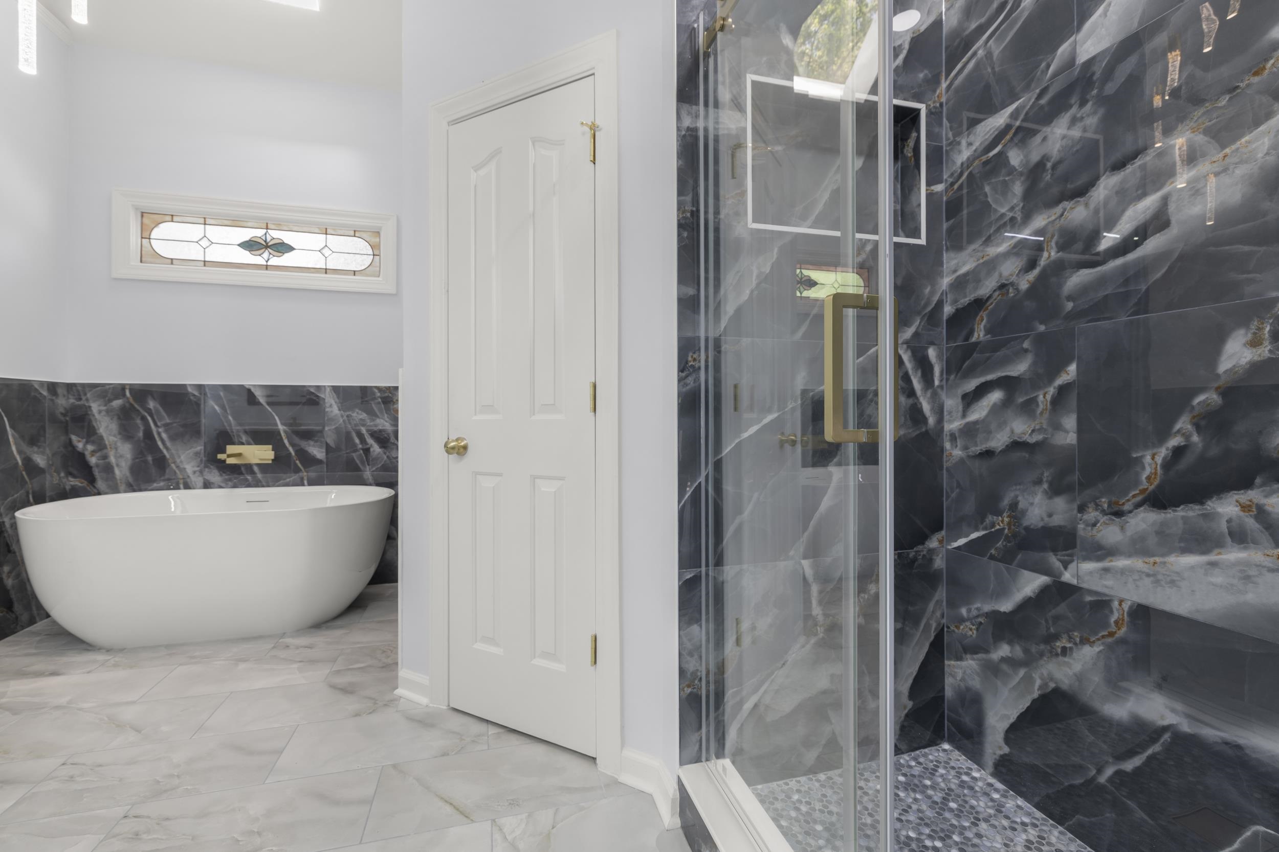 486 Brook Ridge Circle Memphis, TN 38018 - Photo 29 of 40 Bathroom featuring a marble finish shower, tile walls, a freestanding bath, light marble finish flooring, and a wainscoted wall