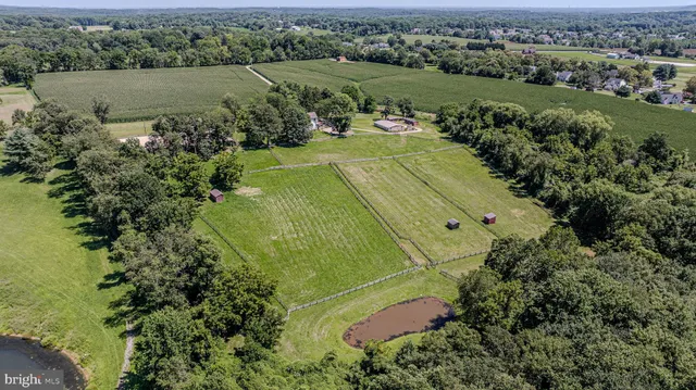 an aerial view of a residential houses with outdoor space and lake view