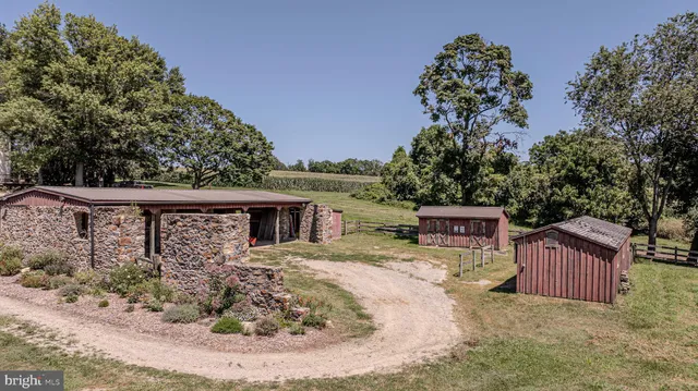 an aerial view of a houses with outdoor space and trees all around