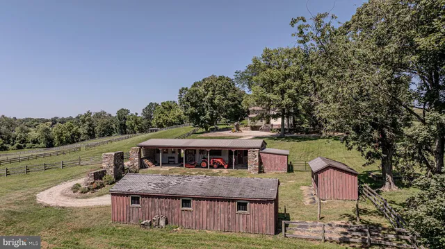 an aerial view of a houses with outdoor space and trees all around