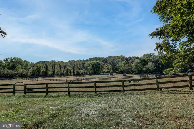 a bed sitting in a bedroom next to a window with a tv