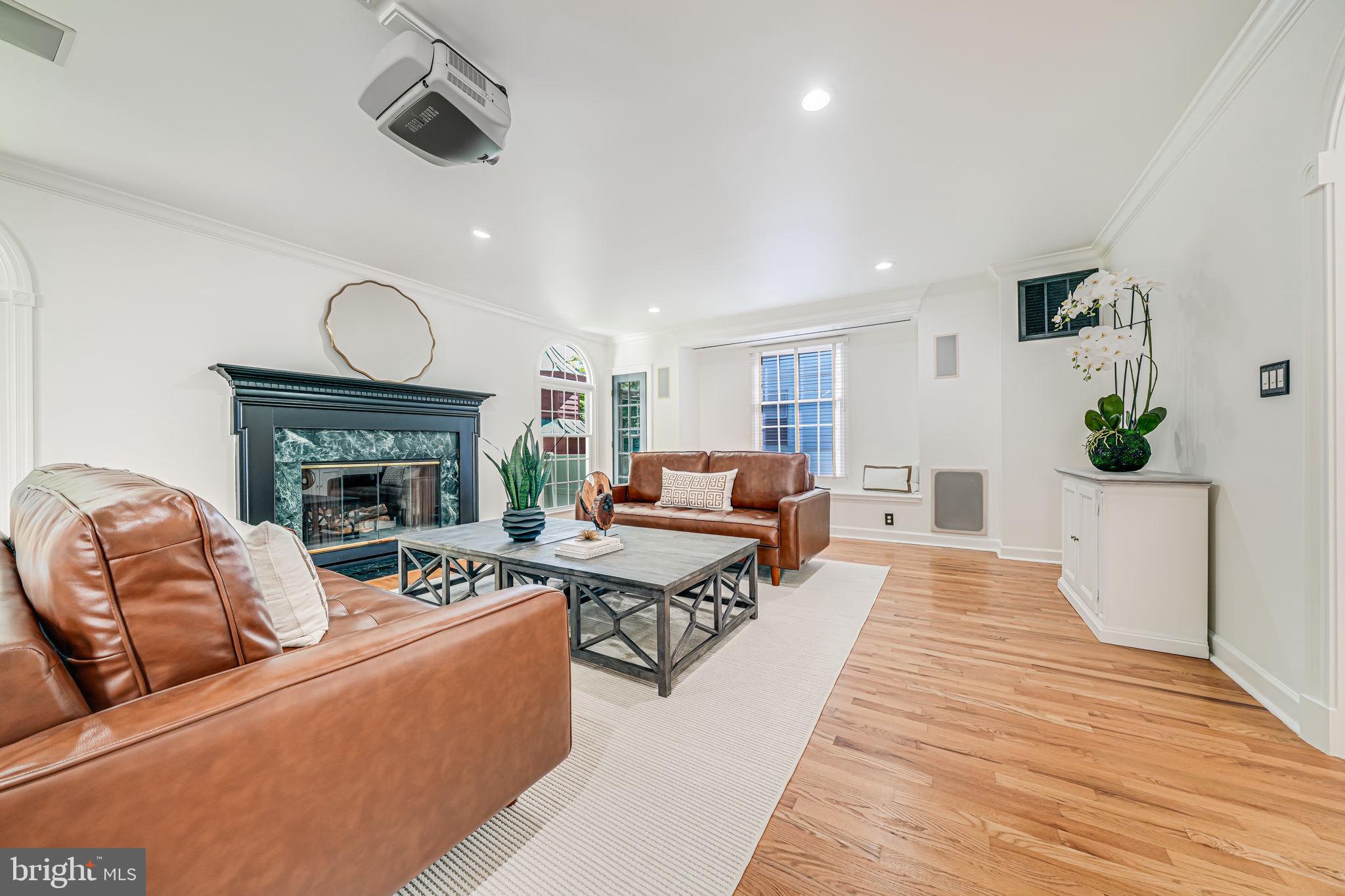 4817 Chevy Chase Boulevard Chevy Chase, MD 20815 - Photo 16 of 78 a living room with furniture a fireplace and a chandelier