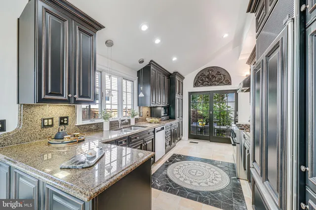 a kitchen with granite countertop stainless steel appliances and wooden floor