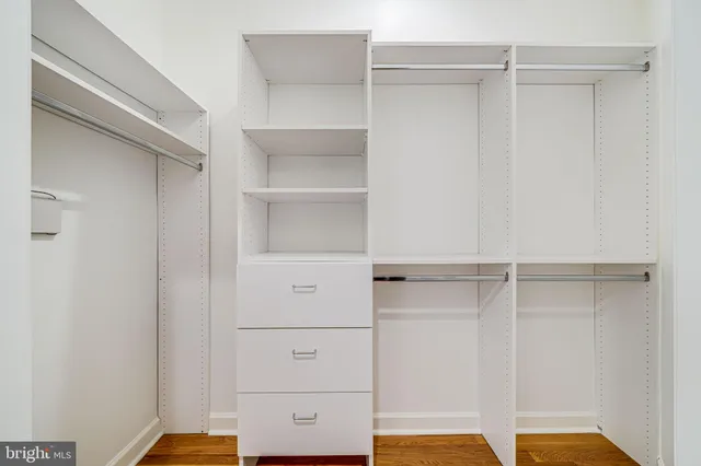 a spacious bedroom with a bed a chandelier and potted plant on the table