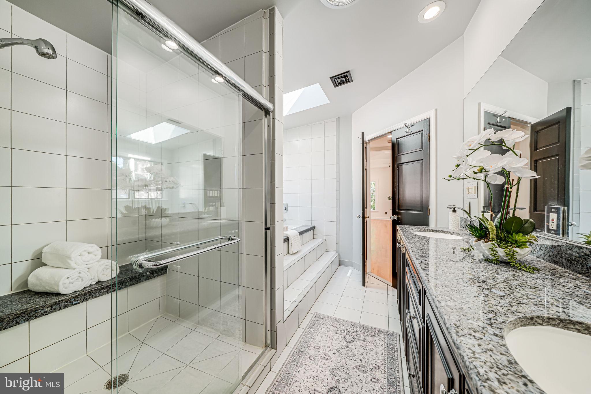 4817 Chevy Chase Boulevard Chevy Chase, MD 20815 - Photo 32 of 78 a spacious bathroom with a granite countertop sink a mirror and shower
