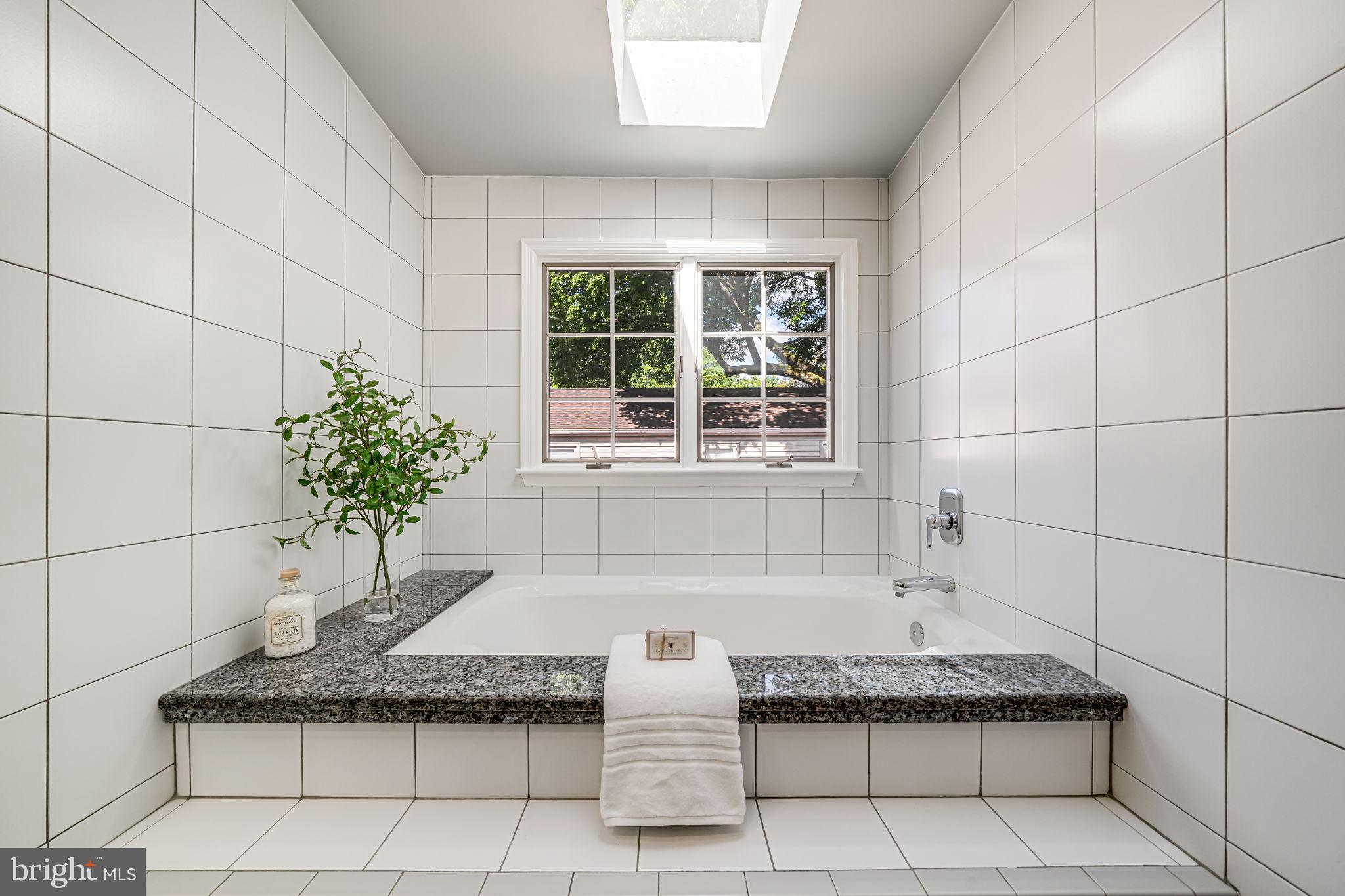 4817 Chevy Chase Boulevard Chevy Chase, MD 20815 - Photo 33 of 78 a bathroom with a granite countertop bathtub and window