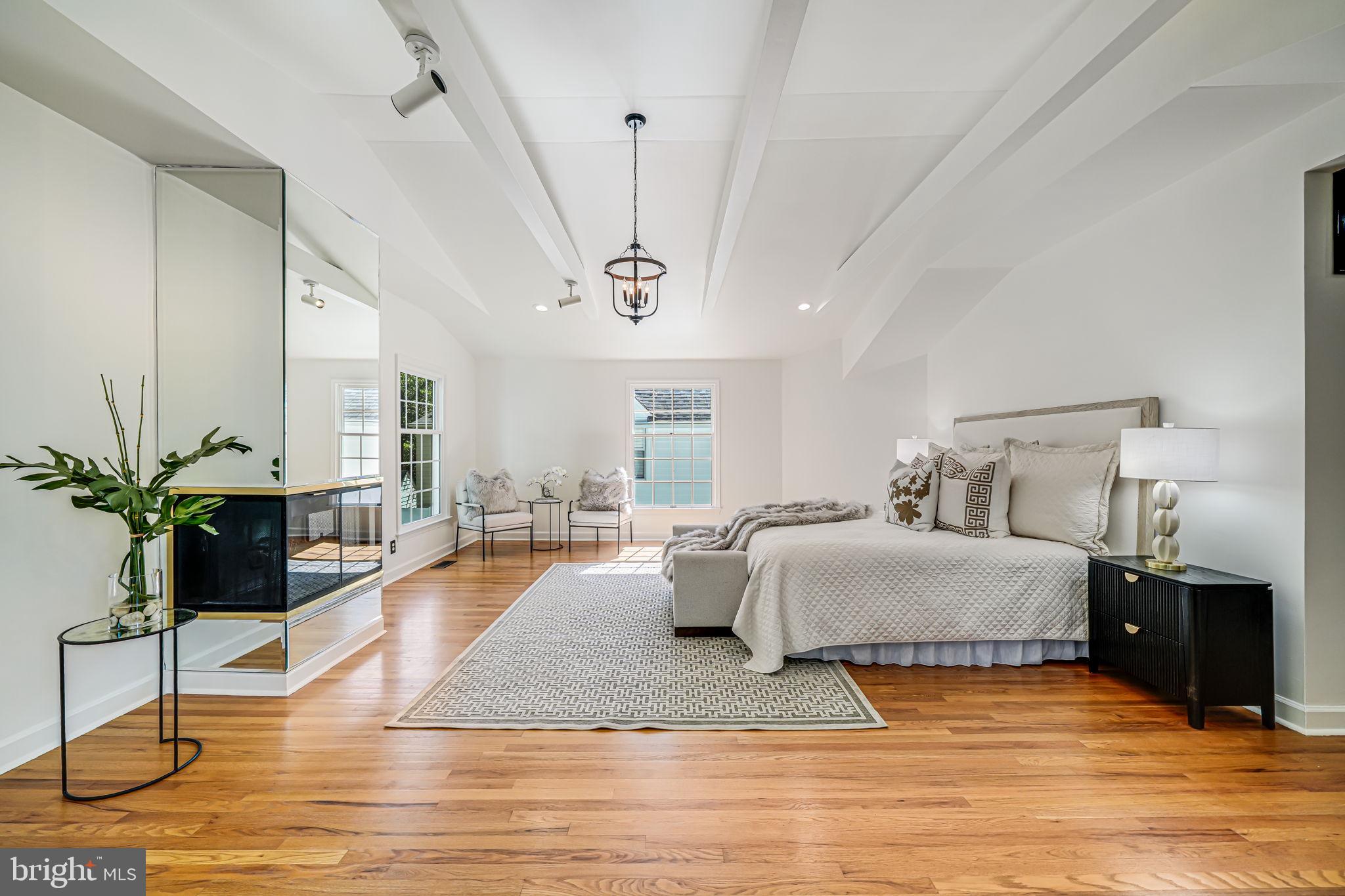 4817 Chevy Chase Boulevard Chevy Chase, MD 20815 - Photo 34 of 78 a spacious bedroom with a bed a chandelier and potted plant on the table