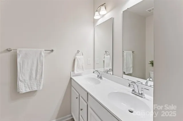a bathroom with double vanity sink and a mirror