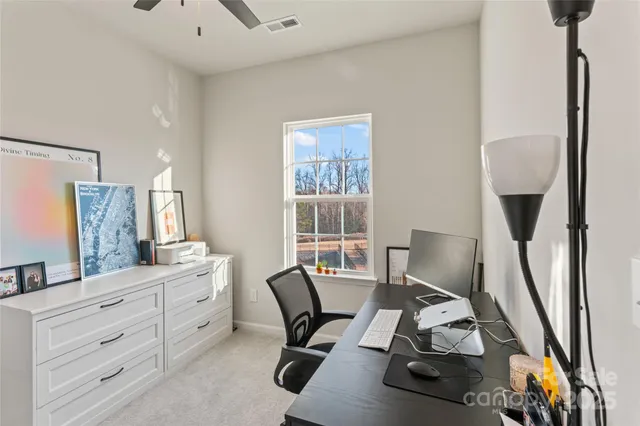 a work room with furniture a rug and a window