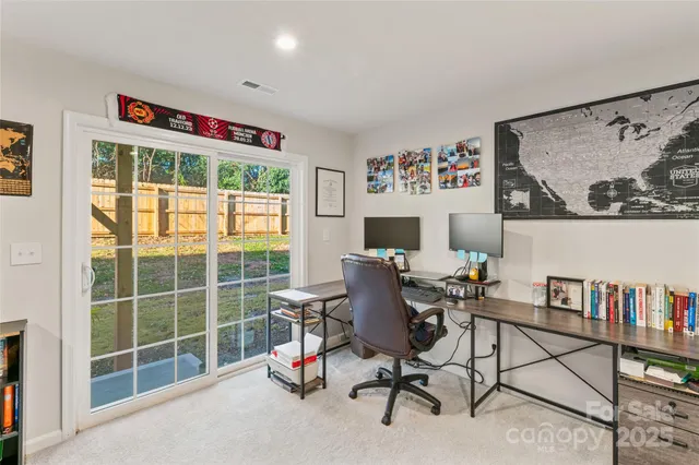 a view of a workspace with furniture and a window