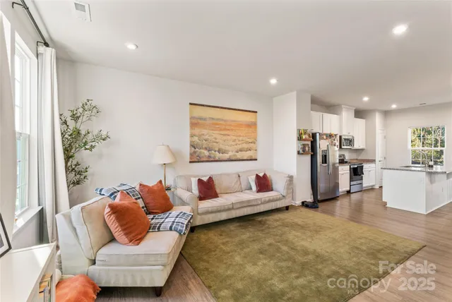 a living room with furniture wooden floor and a large window