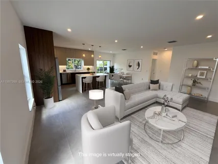 a living room with furniture and a dining table with kitchen view
