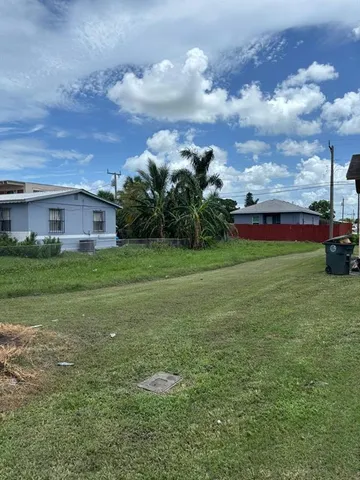 a view of a house with a big yard and potted plants