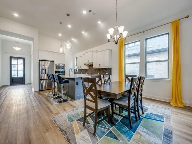 a view of a dining room with furniture and a chandelier