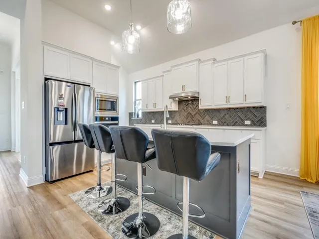 a kitchen with stainless steel appliances a sink stove and cabinets