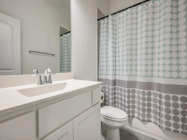 a bathroom with a sink and mirror with toilet